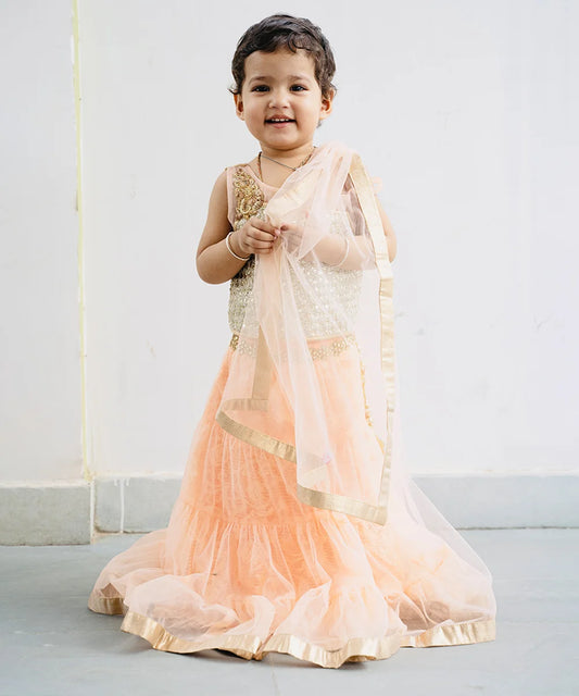 This traditional lehenga for kids consist of a choli, a tiered Lehenga and a dupatta for your kids with a back hook closure. It features embellished shoulder and choli. Moreover, skirt has a lace work on the waist and tassel detailing on it.