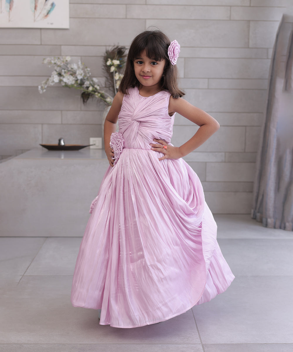 This pink coloured baby birthday party dress consists of a gown with beautiful floral and knot detailing. Moreover, it comes with a fabric belt to be tied at the back.