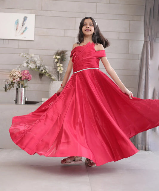 It’s a red coloured fancy gown with a back zip closure that comes with a matching inner making it a perfect children's birthday dress and a girl's wedding outfit. It features a beautiful belt detailing on the waist and pleated detailing on the yoke that uplifts the entire look.