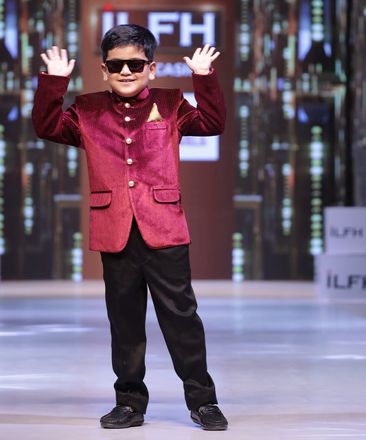 This Maroon party dress for boys consists of a Jodhpuri coat and matching black pants. It features a cute broach and golden-colored pocket square that adds grace to the look.