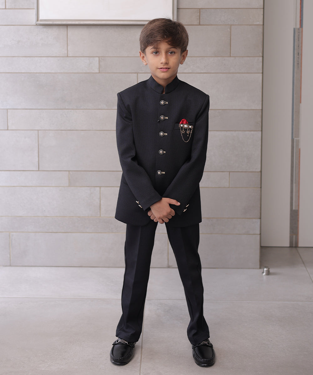  It is a black Jodhpuri suit set which consists of a Jodhpuri Coat along with matching pants. It features stylized buttons, a red coloured pocket square and a nice broach.