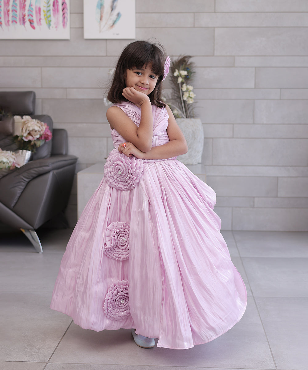 This pink coloured baby birthday party dress consists of a gown with beautiful floral and knot detailing. Moreover, it comes with a fabric belt to be tied at the back.