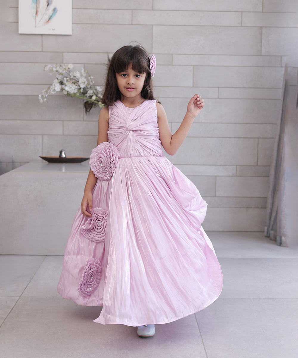 This pink coloured baby birthday party dress consists of a gown with beautiful floral and knot detailing. Moreover, it comes with a fabric belt to be tied at the back.